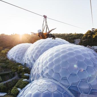 Person on zip wire over Eden Project